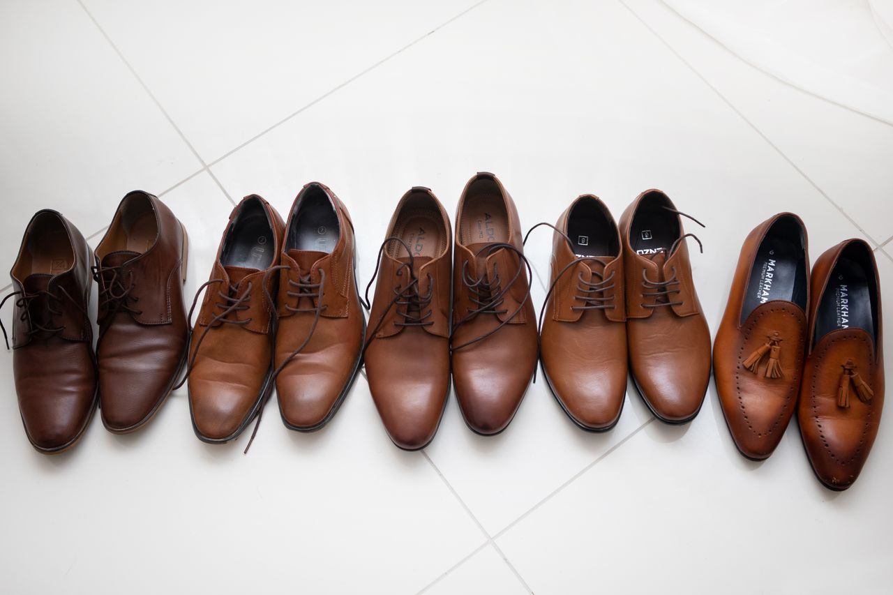 services-03 Lineup of various men's leather shoes showcasing elegance and style on a polished white tile floor.